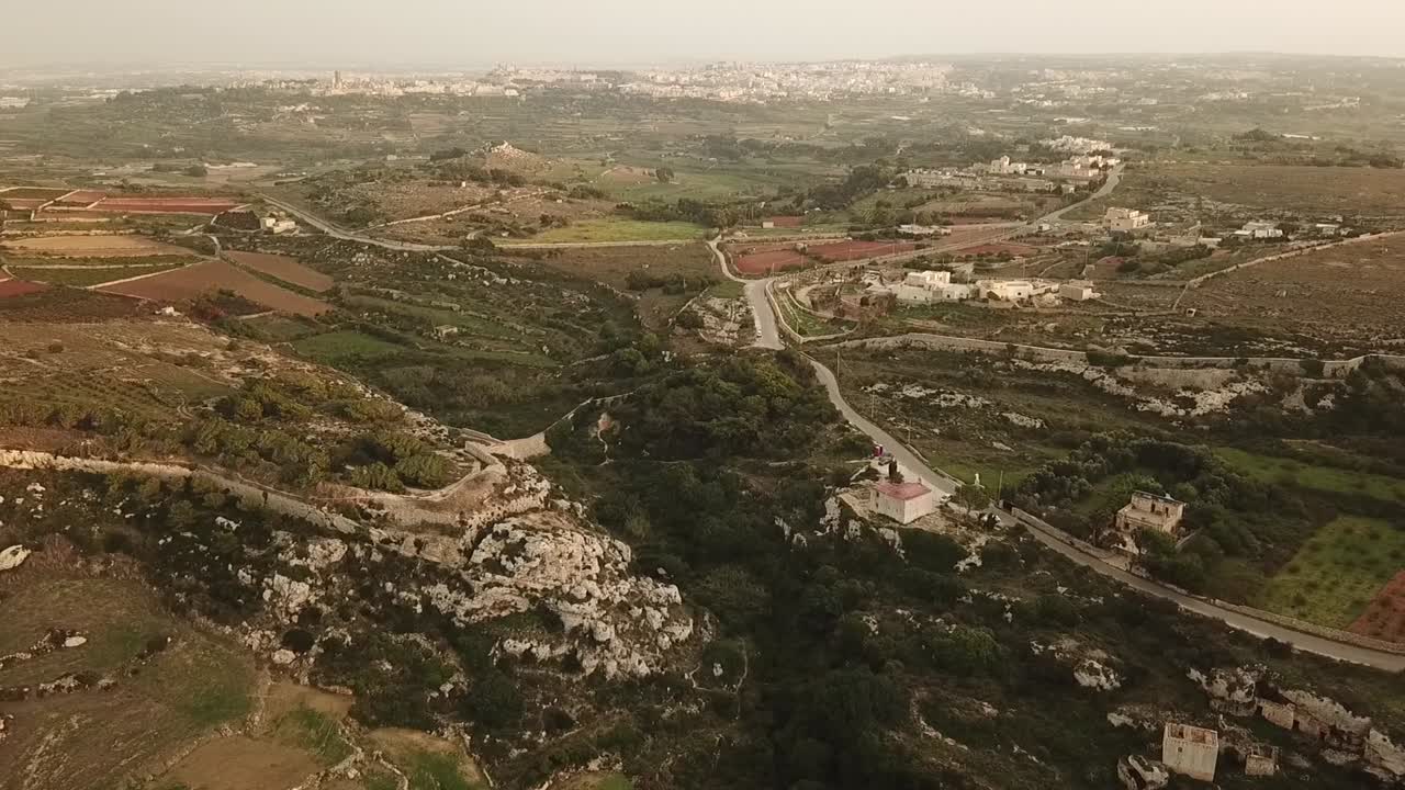 Aerial view of the Victoria Lines, Malta, Europe. Dolly shot flying towards the valley, chapel and wall.
