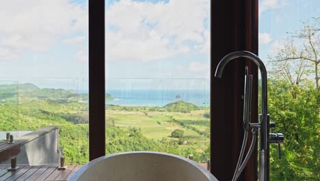 freestanding stone bathtub with scenic views across the mountain valley to lombok's southern selong beach