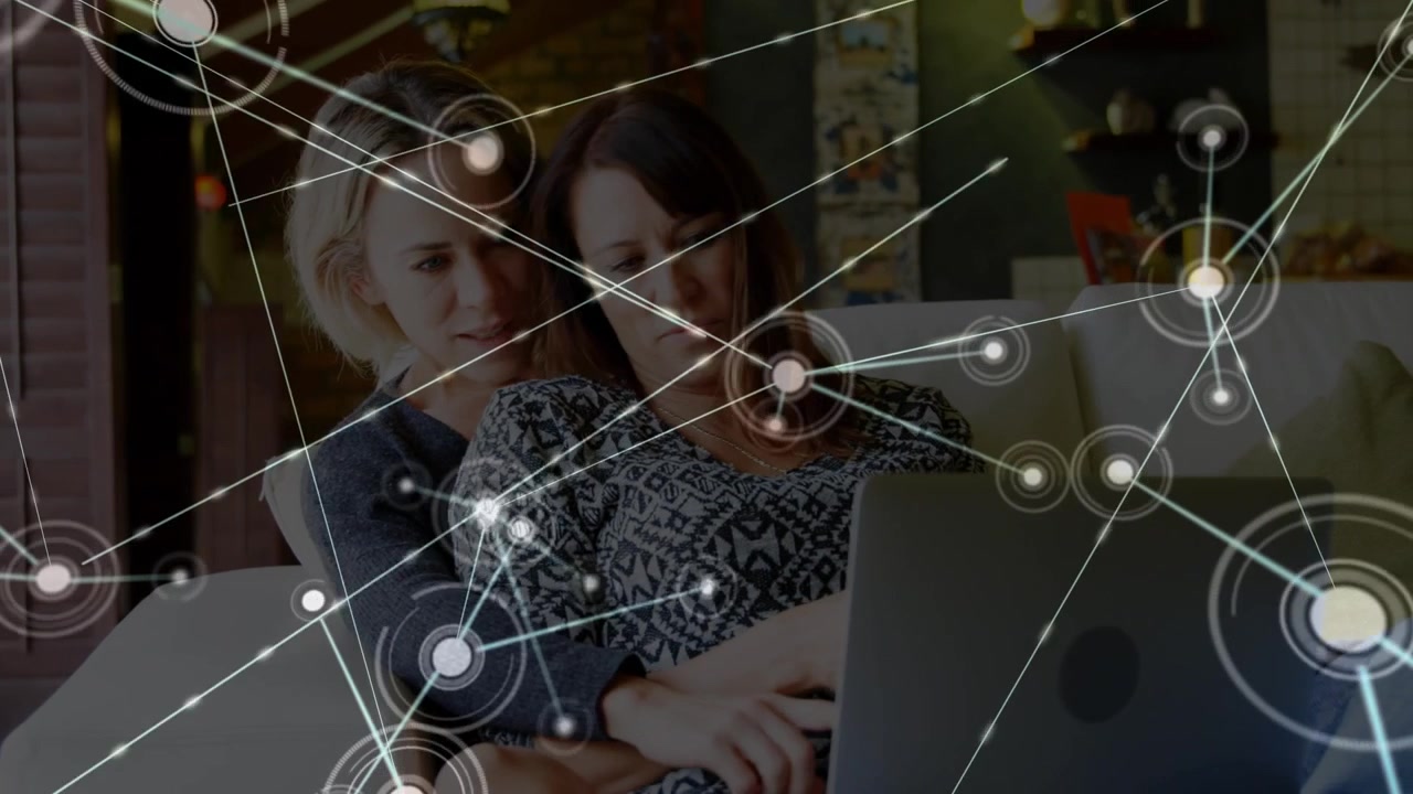 Animation of network of connections over caucasian female couple using laptop