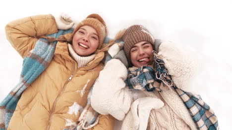 two friends having fun in the snow