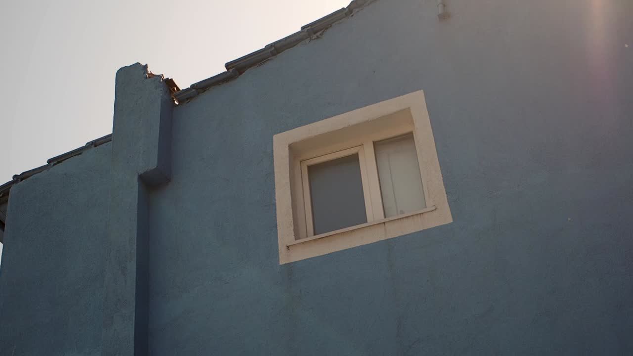 primer plano de un edificio azul con una ventana