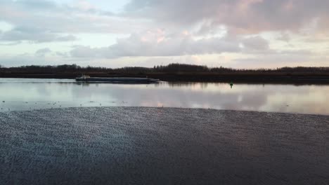 industrial barge sailing to antwerp harbor on beautiful evening time, aerial fly towards