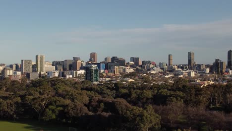 tomada de avión no tripulado del cbd de adelaide, moviéndose de derecha a izquierda, con los parques de adelaide en primer plano