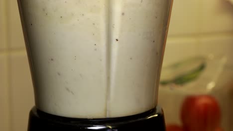 close up of food blender with ingredients being mixed together