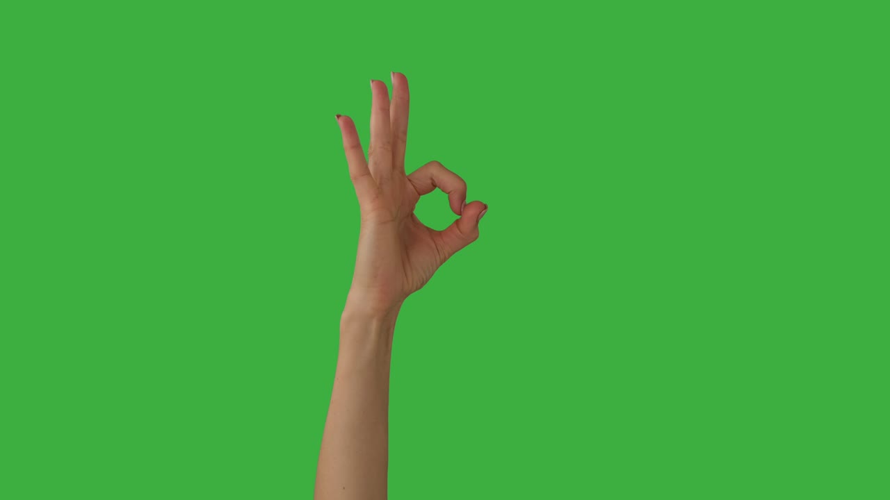 mano que muestra el signo ok sobre fondo verde
