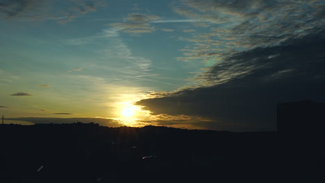 a bright blue sky with an orange sunset is covered by dark clouds, clouds move and build new layers in the sky