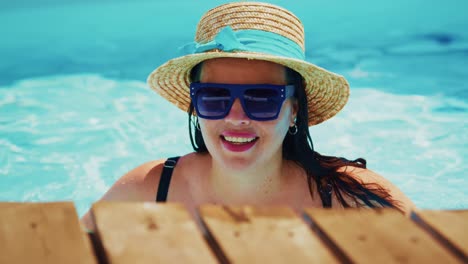 woman enjoying a refreshing swim in a pool, wearing sunglasses and a straw hat, summer vibes