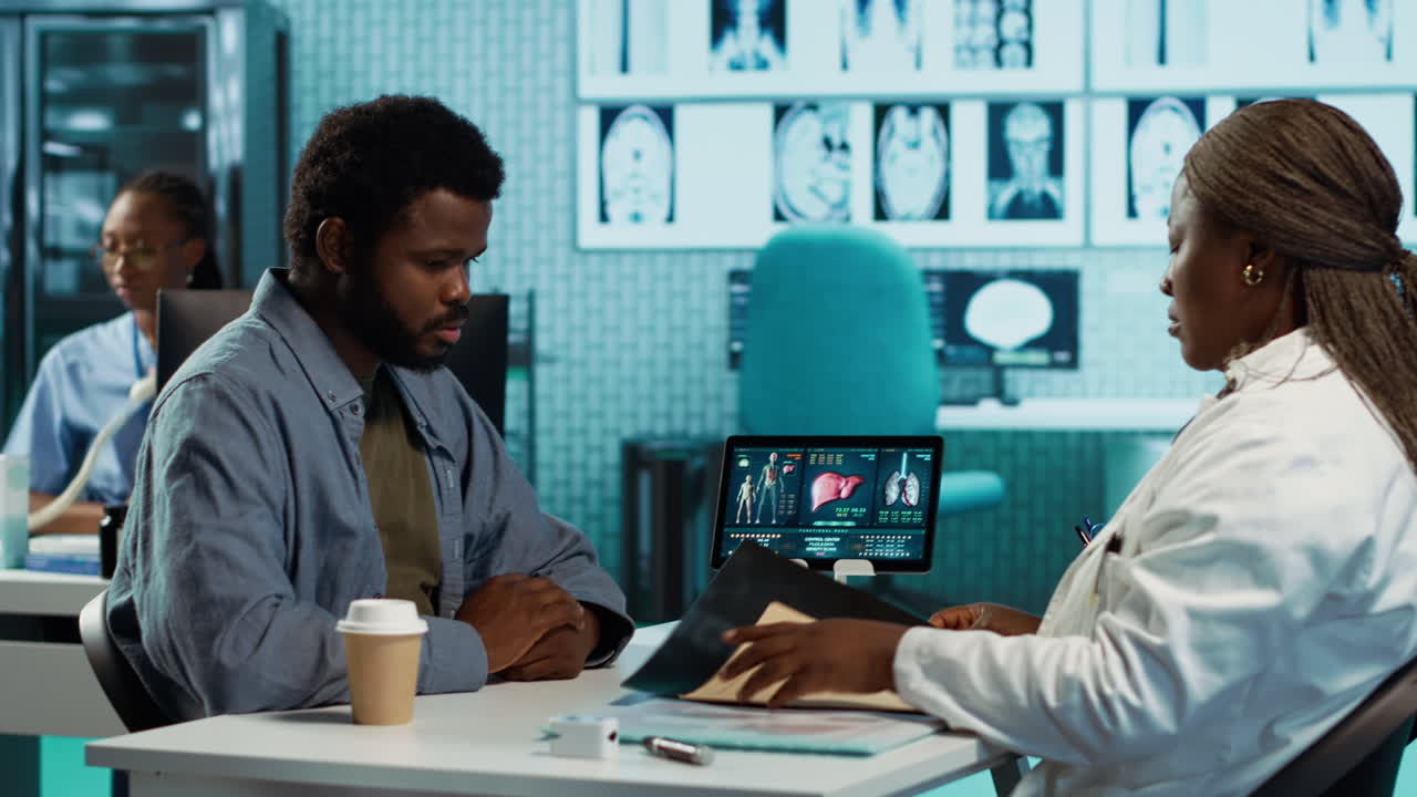 African american young man and specialist review ct scans and x rays