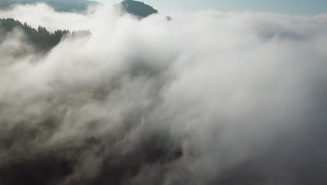 Flying-above-the-clouds-during-sunset-in-Gran-Canaria:-aerial-view-traveling-in-over-sea-of-clouds-and-mountainous-landscape-in-the-city-of-Valleseco