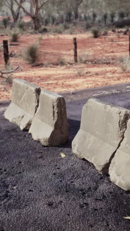 concrete barriers blocking a road in the australian outback