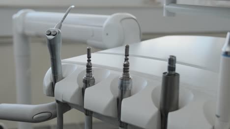 Close-up-of-dental-tools-in-a-dentist's-office-as-a-the-detist's-hand-replaces-the-water-and-air-spray