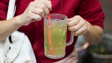 stirring and mixing a colorful fruit drink