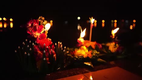 loy krathong festival: close-up shot of colorful krathongs with a burning candles and incense on top