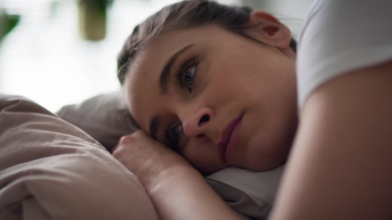 vídeo en primer plano de una mujer triste acostada