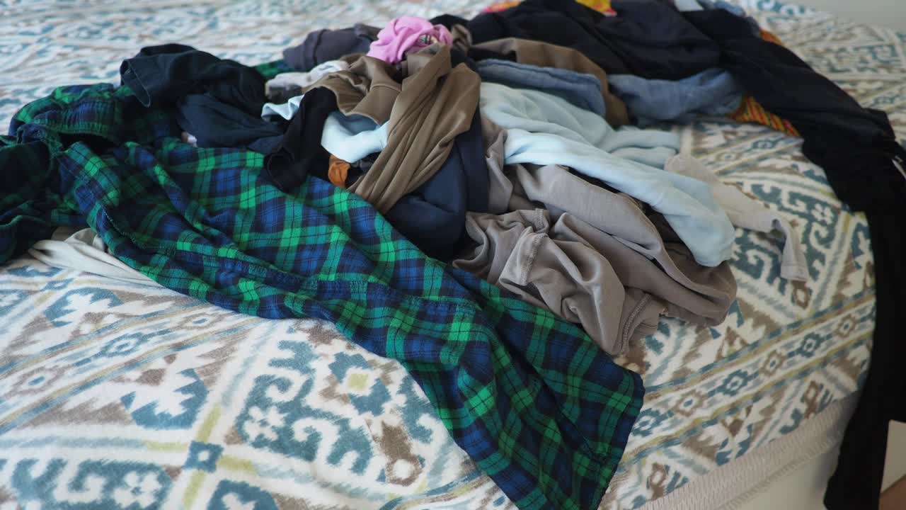 침대 위 에 있는 옷 어리