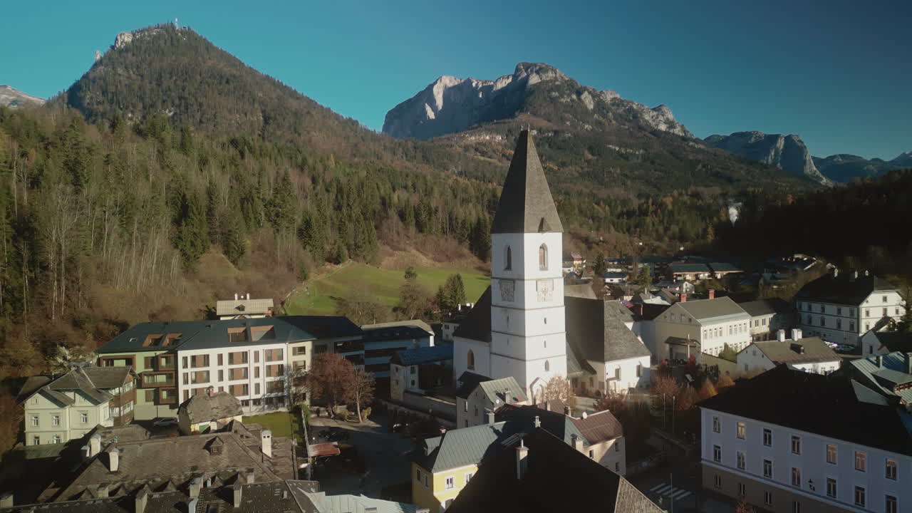 Picturesque Village with Church and Mountain Backdrop