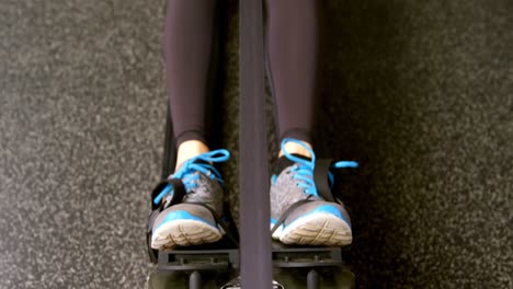 Determined-Caucasian-woman-exercising-with-rowing-machine-in-fitness-studio-4k