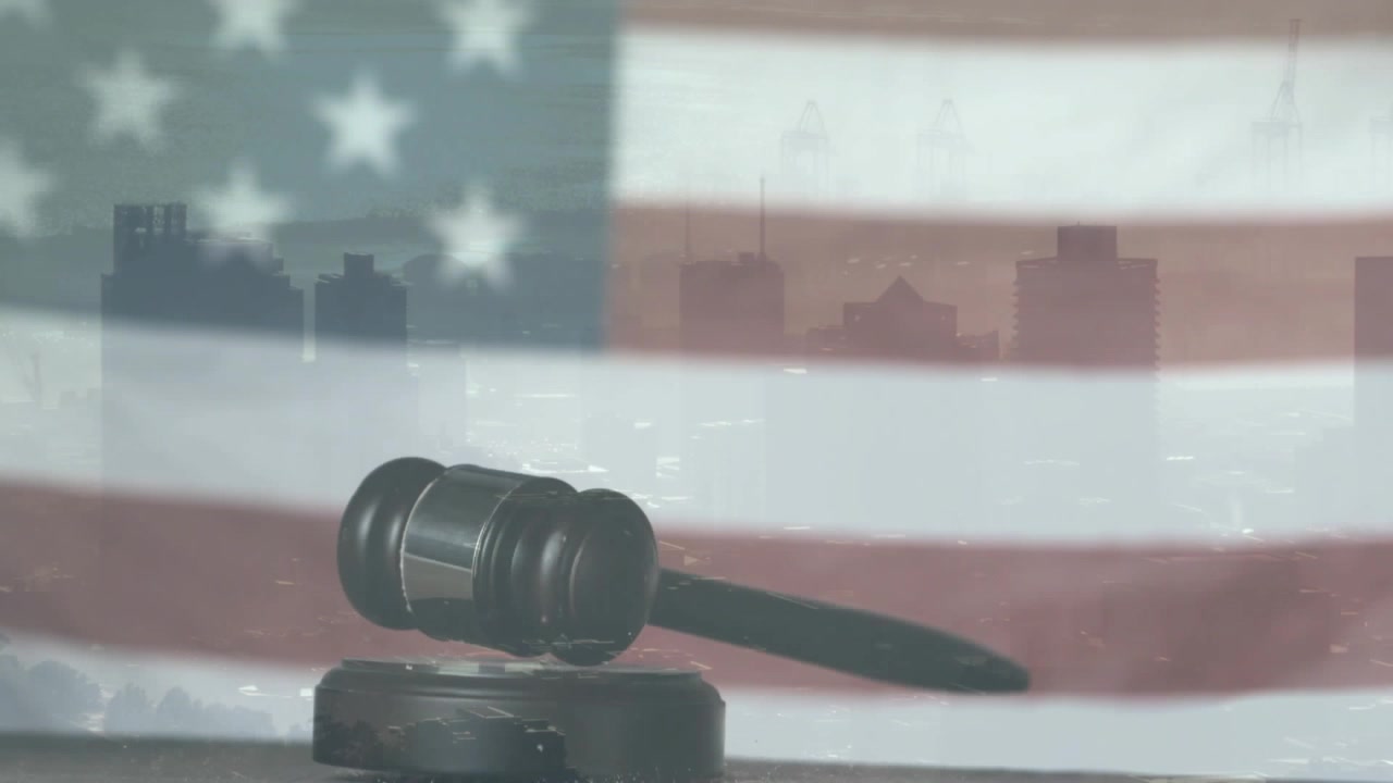 Gavel dropping, rotating and striking sound block before faded flag and skyline, showing justice