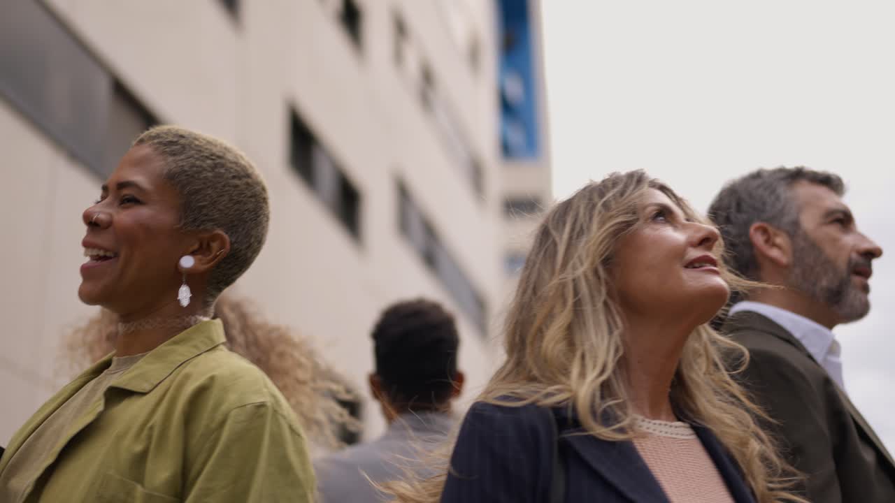 Diverse Group of People Looking Up at Buildings