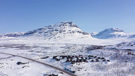 vista aérea de un pequeño pueblo en un paisaje montañoso nevado