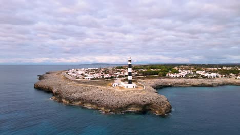 faro de artrutx sentado al final de un acantilado rocoso en menorca, españa