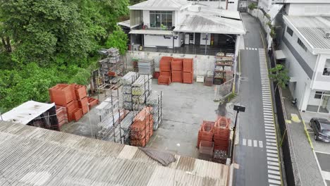 An-open-air-warehouse-with-forklifts,-pallets-and-dismounted-scaffoldings