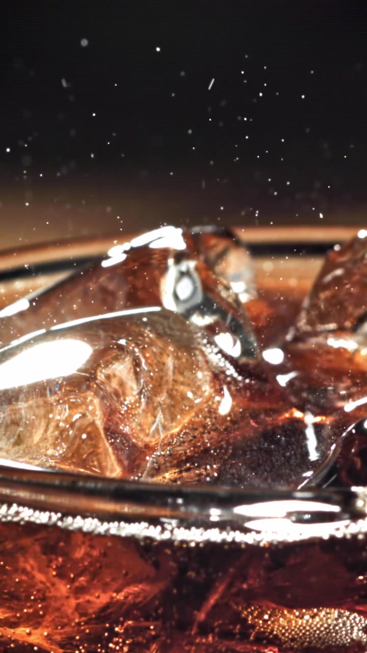 Bevanda rinfrescante alla cola con cubetti di ghiaccio ed effervescenza.