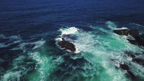 aerial view of ocean waves crashing on rocky coast
