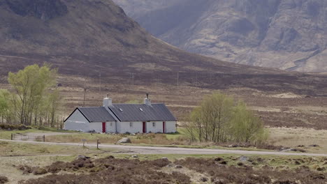 Aerial-footage-of-Blackrock-Cottage-on-a-sunny-day,-Glencoe,-Scottish-Highlands,-Scotland