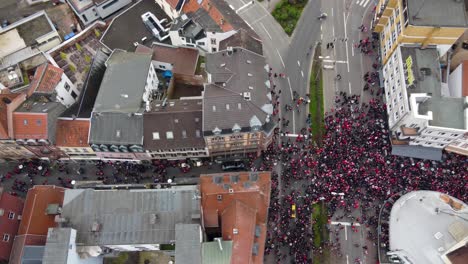 crowds of fck kaiserslautern audience fans celebrating on street intersection after winning football match, germany