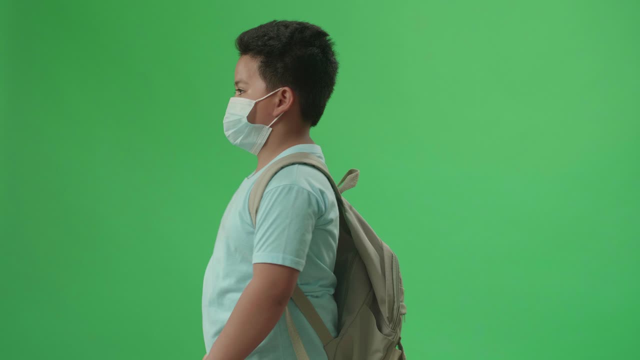 Side View Of Asian Boy Student Walking To School On Green Screen Chroma Key