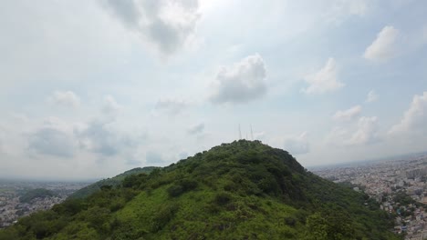 aerial view of a city overlooking green hills and mountains
