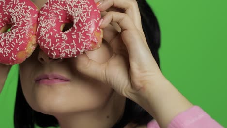 feliz joven hermosa posando y divirtiéndose con rosquillas. llave de croma