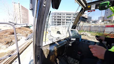 crane operator at construction site commands truck to move rebar to another area