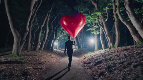 man walking through forest at night with a giant heart balloon