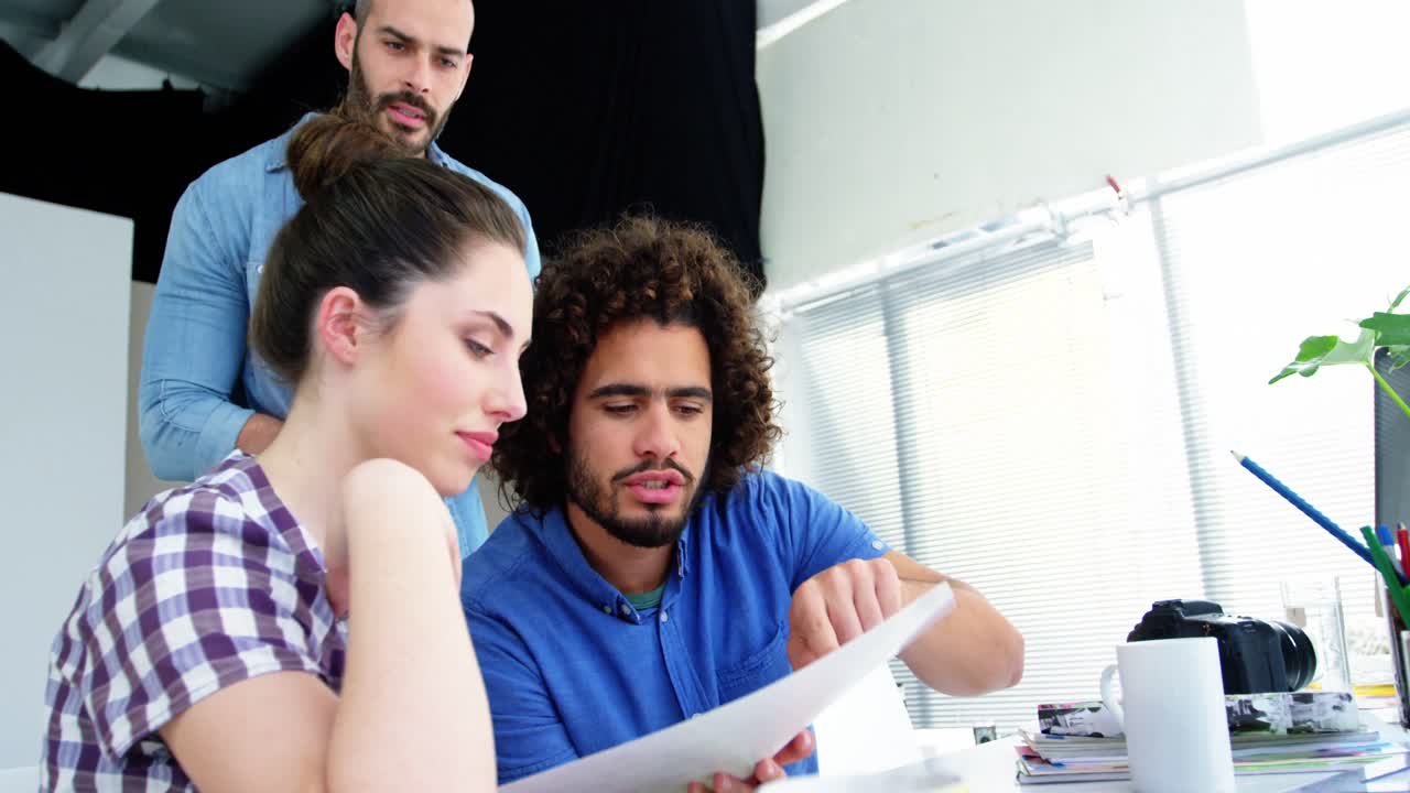 diseñadores gráficos masculinos y femeninos interactuando entre sí