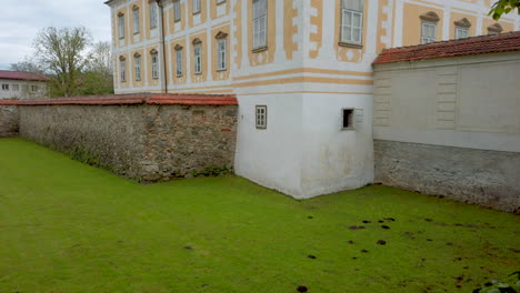 Renaissance-Baroque-palace-in-medieval-European-town,-Castle-in-Slovenska-Bistrica,-Slovenia,-defensive-trench-with-stone-walls-and-tower