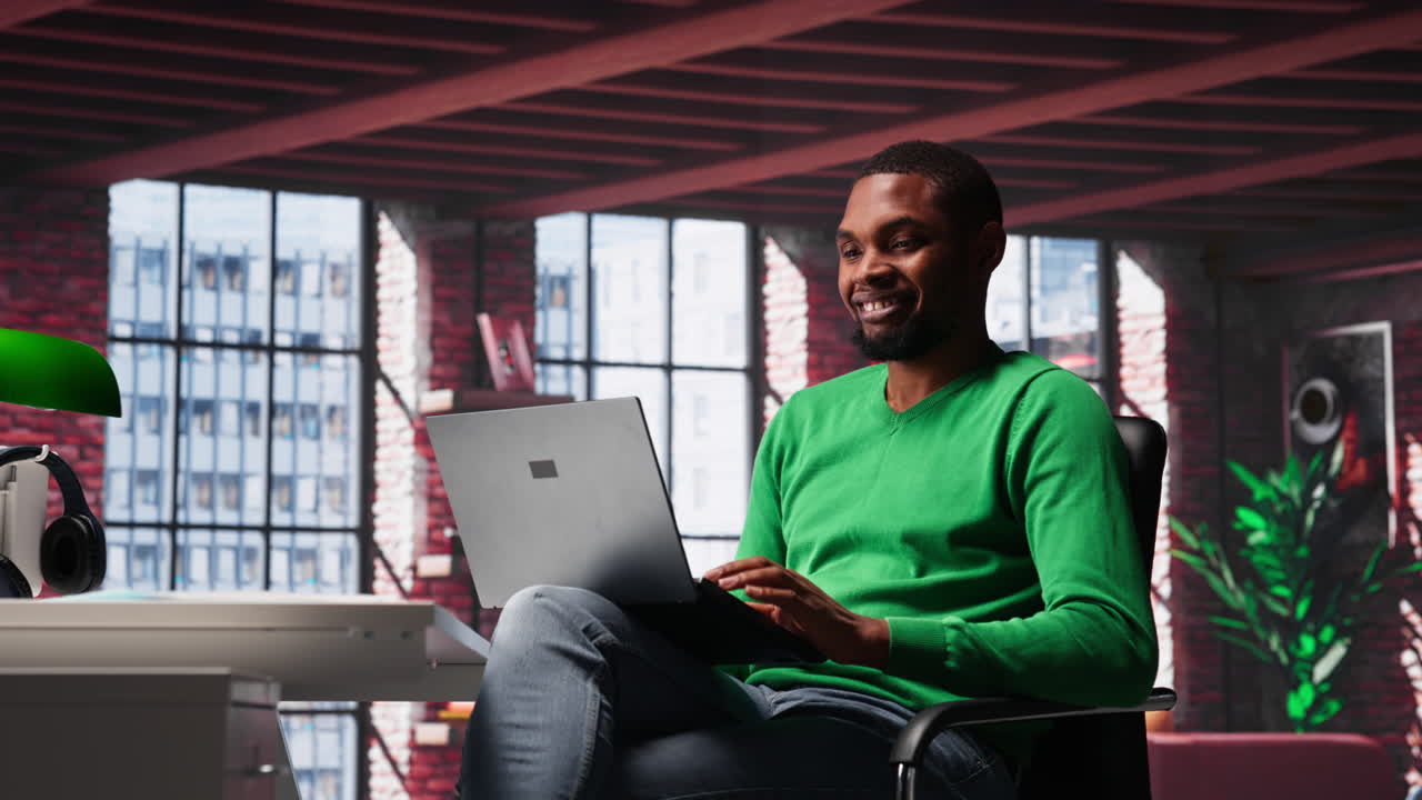Vertical Video African american guy in loft opening laptop in the morning to work