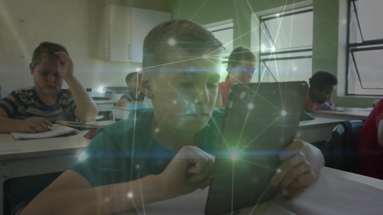 Schoolboy tapping tablet while network overlay appearing panning revealing classmates for education