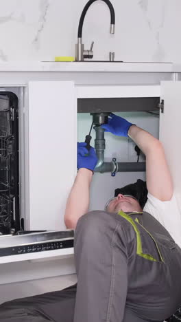 plumber repairing kitchen sink drain