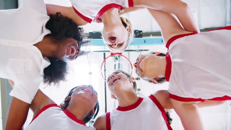 low angle view of female high school basketball players having team talk with coach