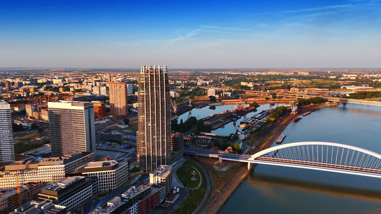 Going down over the Danube in Bratislava, Slovakia at sunset time. Modern cityscape of the city, port and the arched Appolo Bridge