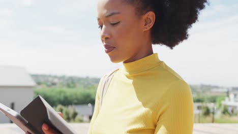 Happy-african-american-businesswoman-using-tablet-at-street,-slow-motion