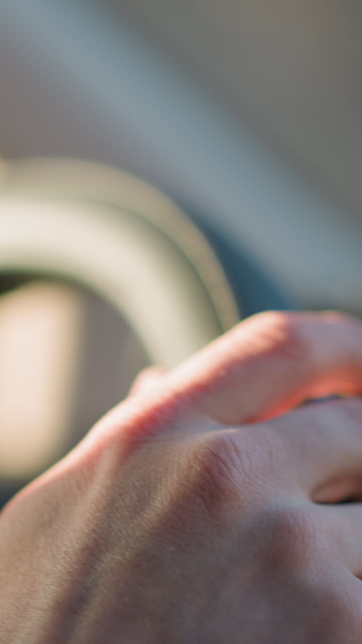 vista en primer plano de las manos de un hombre agarrando el volante de un automóvil, destacando la textura y los detalles de las manos y el volante