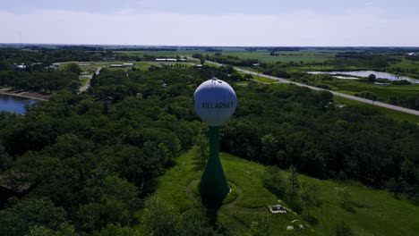 long video drone full 360 degree hyper time lapse of the historic killarney lake manitoba canada landscape lakeside green ireland iconic historic architecture shamrock water tower in the summer time