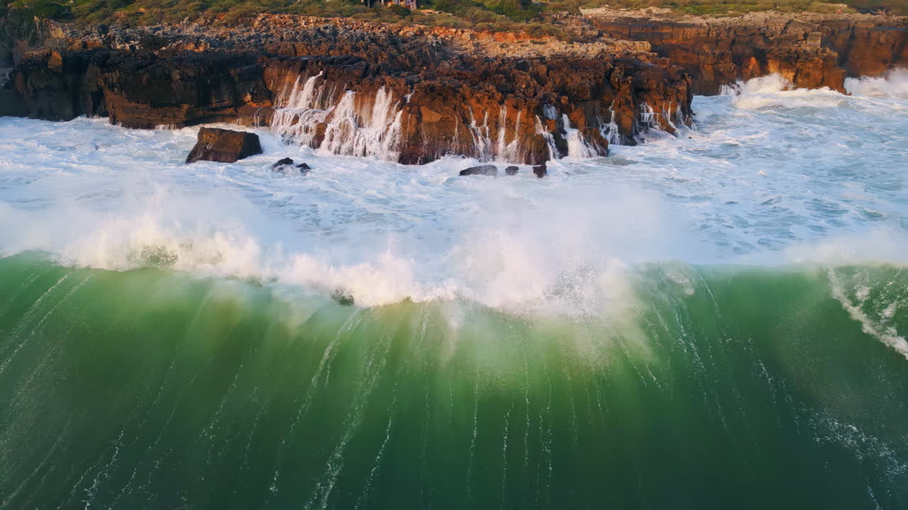Foaming water splashing rocks coastline close up. Sea waves crashing at cliffs