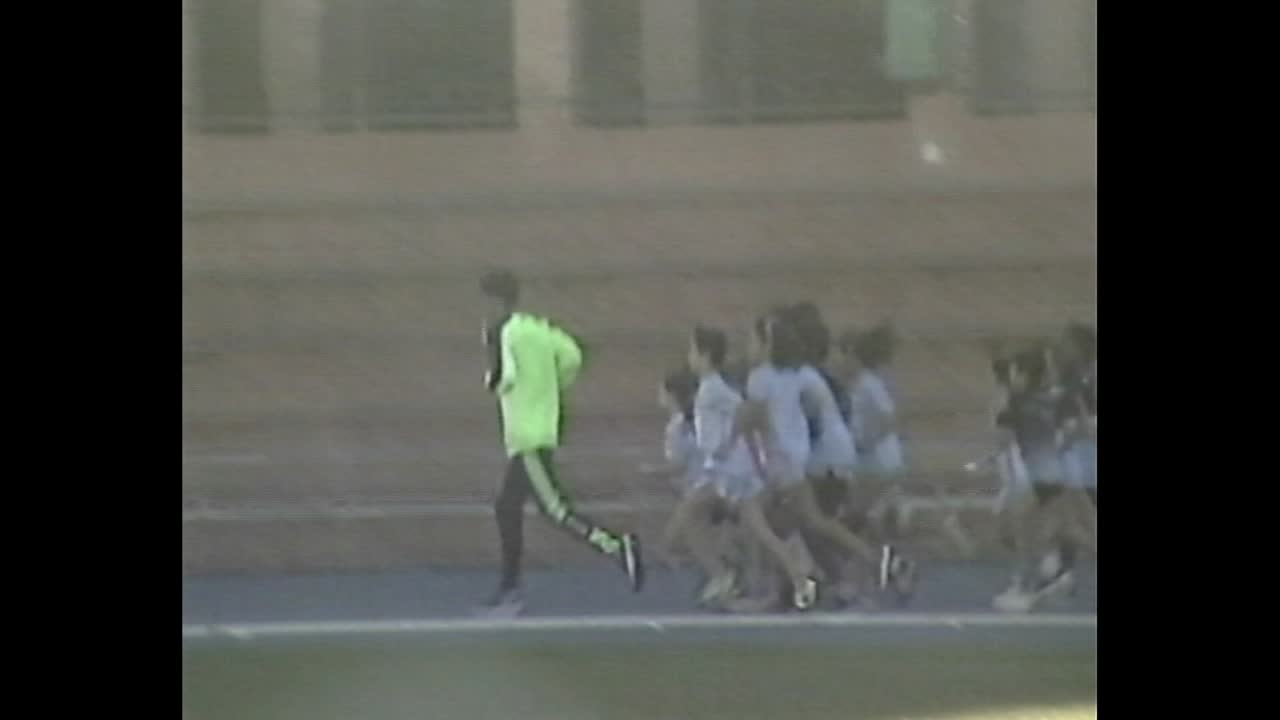 Coach leading children in track practice