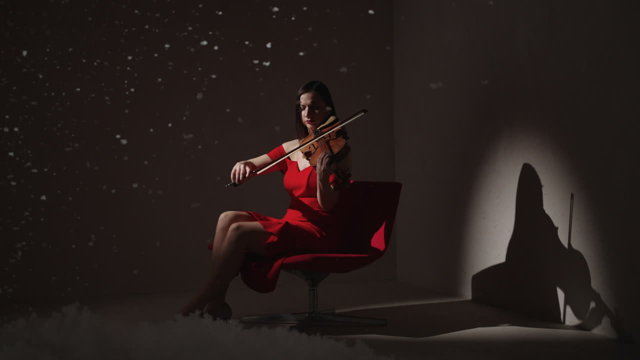 mujer tocando el violín en vestido rojo