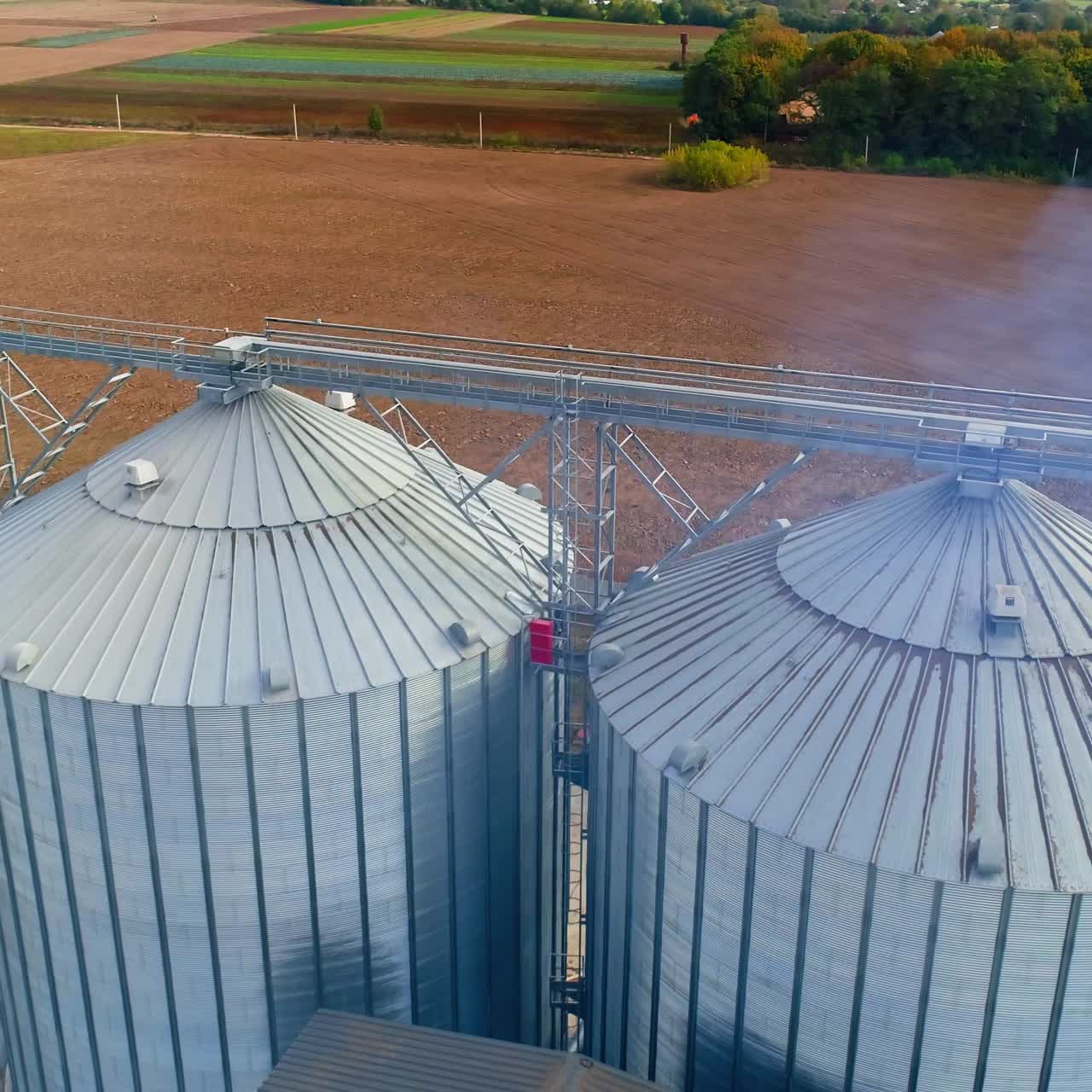 Special grain elevators for crop storage. Metal bridge from the roof of metal tank. View from above. Video from the top. Closeup