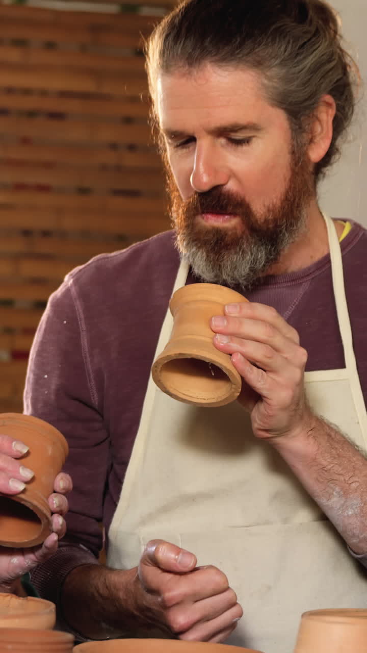 hombre y mujer alfareros interactuando mientras examinan una olla